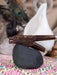 Wooden smoking pipe with dragon design on a black stone, blurred background