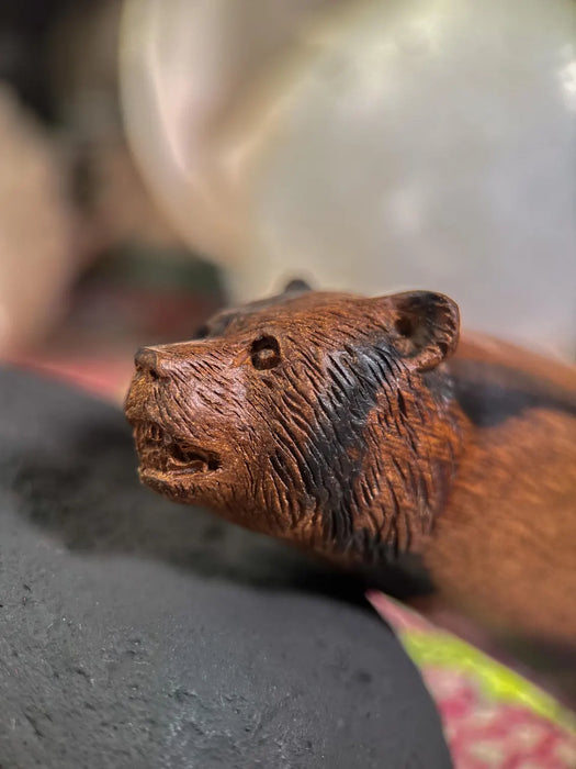 Close-up of a brown bear figurine on a gray surface with a blurred background