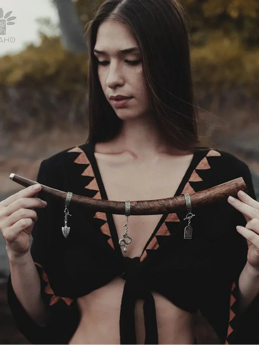 Woman holding a wooden object with a blurred natural background