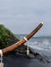 Wooden stick with silver earrings against a coastal background