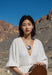 Woman in a white dress holding a guitar in a desert setting