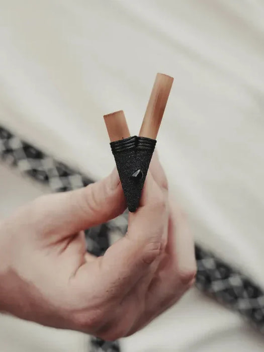 Hand holding two lip liners against a blurred background