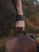 Rust-brown buffalo leather bracelet with triple-infinity loop design — a tribute to ancestral craftsmanship and natural power.