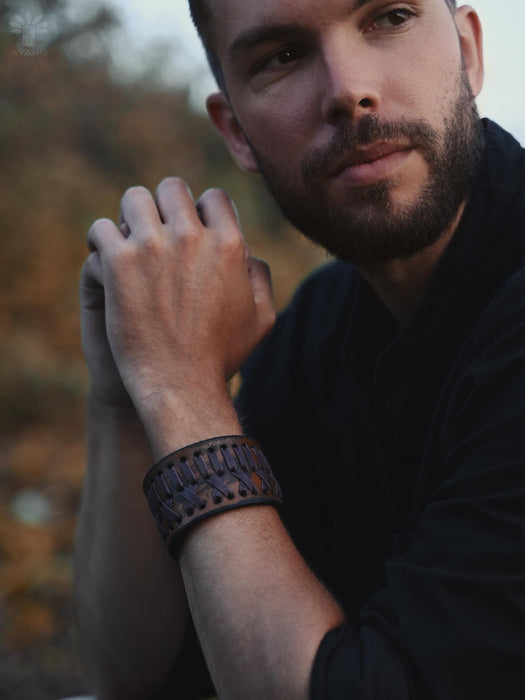 "Buffalo leather bracelet in warm rust-brown with a sculptural triple-infinity design, symbolizing cycles of energy and balance.