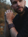 "Buffalo leather bracelet in warm rust-brown with a sculptural triple-infinity design, symbolizing cycles of energy and balance.