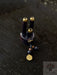 Small wooden object with gold accents and beads on a dark surface, featuring the AYAOH brand.