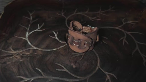 Bold buffalo leather cuff with a triple-infinity pattern, representing continuous energy circulation and spiritual power.