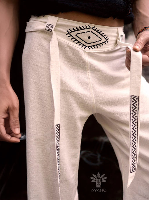 White pants with black patterns held by a person, featuring the Ayaho brand logo.